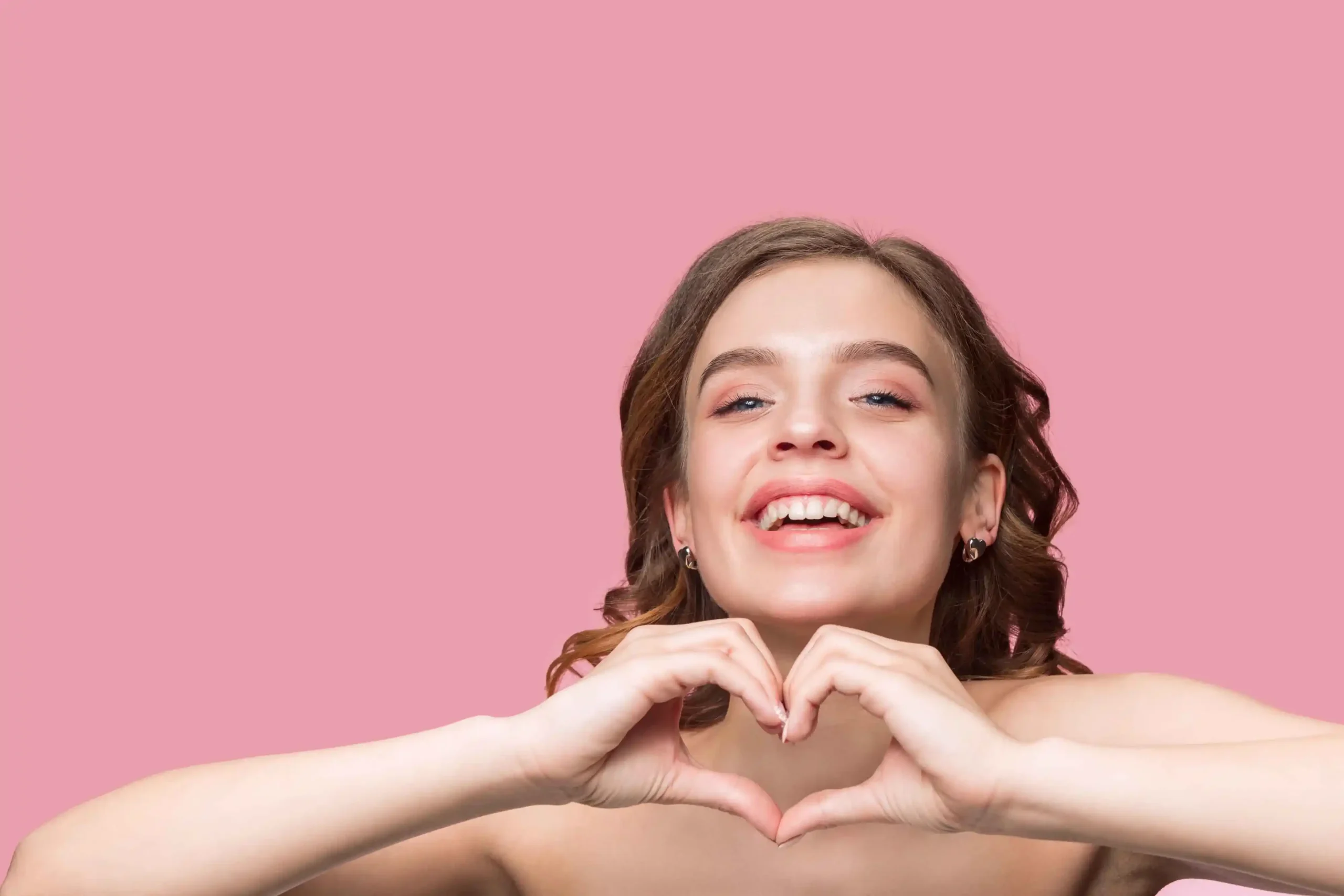 nice young smiling woman with long wavy silky hair natural make up with hand near chin isolated pink wall 1 11zon 1 11zon 11zon scaled